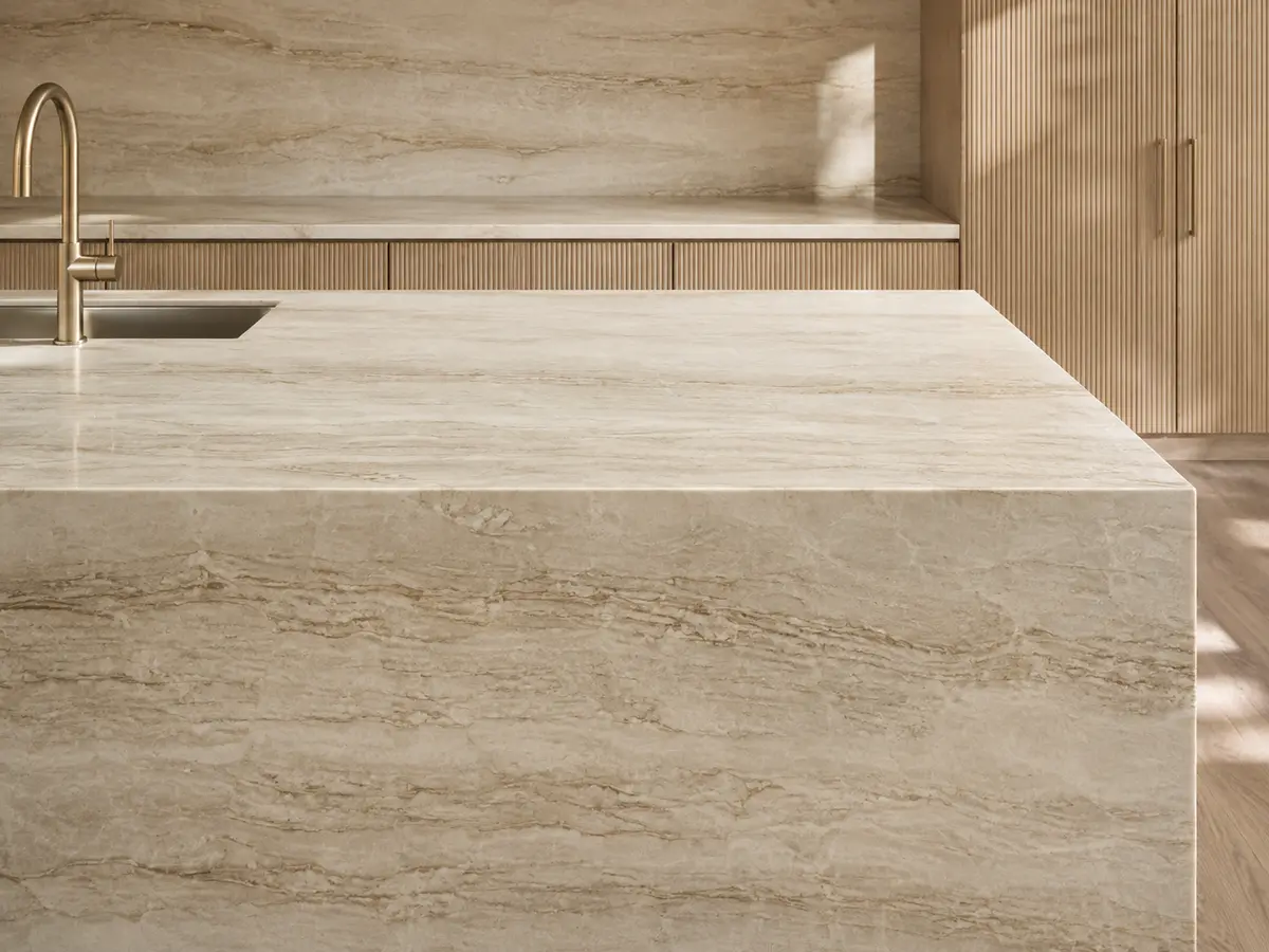 Cream quartzite countertop with layered mineral patterns, a waterfall edge, and wood cabinetry.