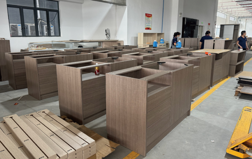 Custom furniture cabinets undergoing production and quality checks at the OKBuild manufacturing facility in China.