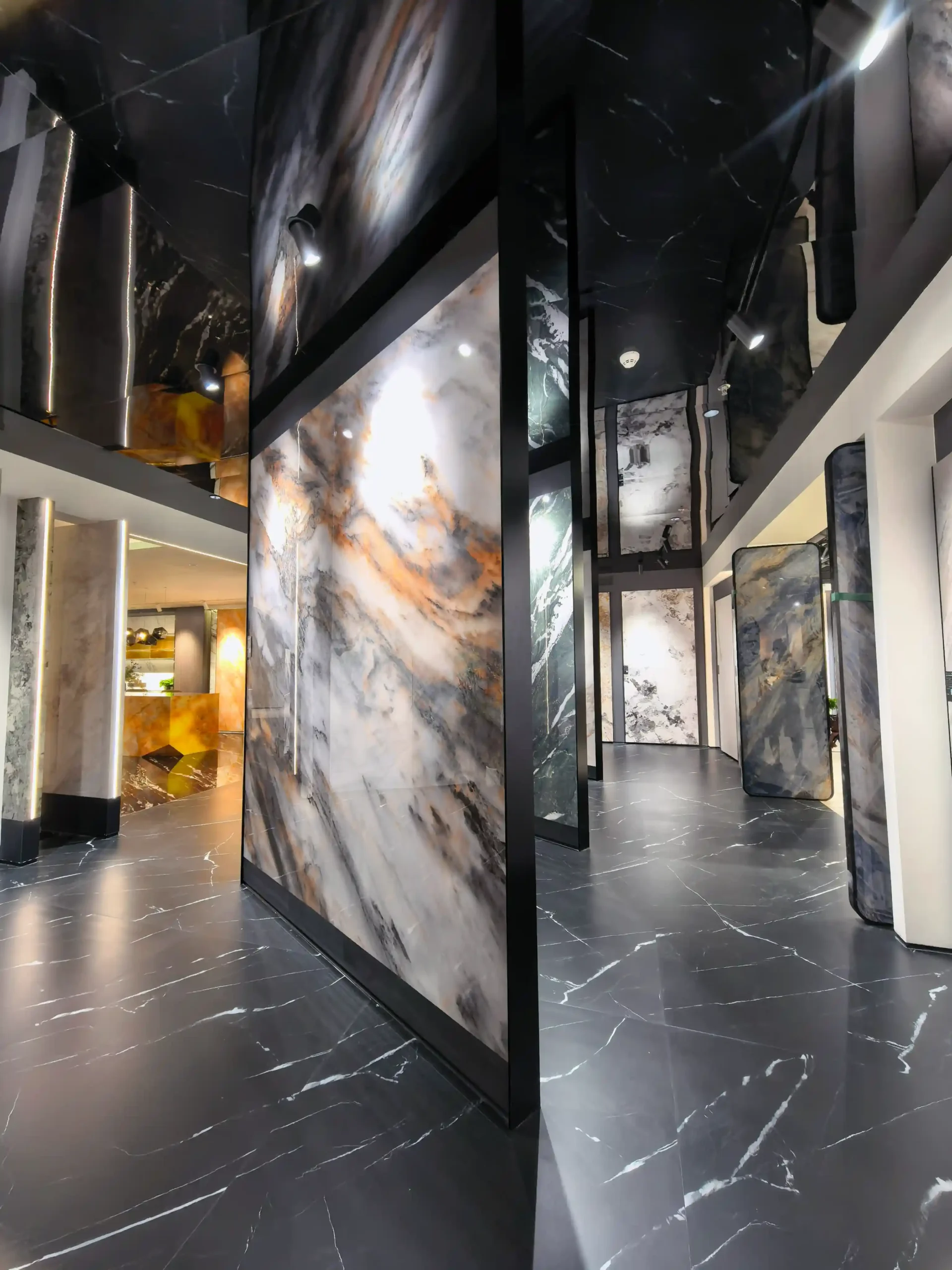 Large-format marble look tiles with black, white and gold veining displayed in a modern tile showroom