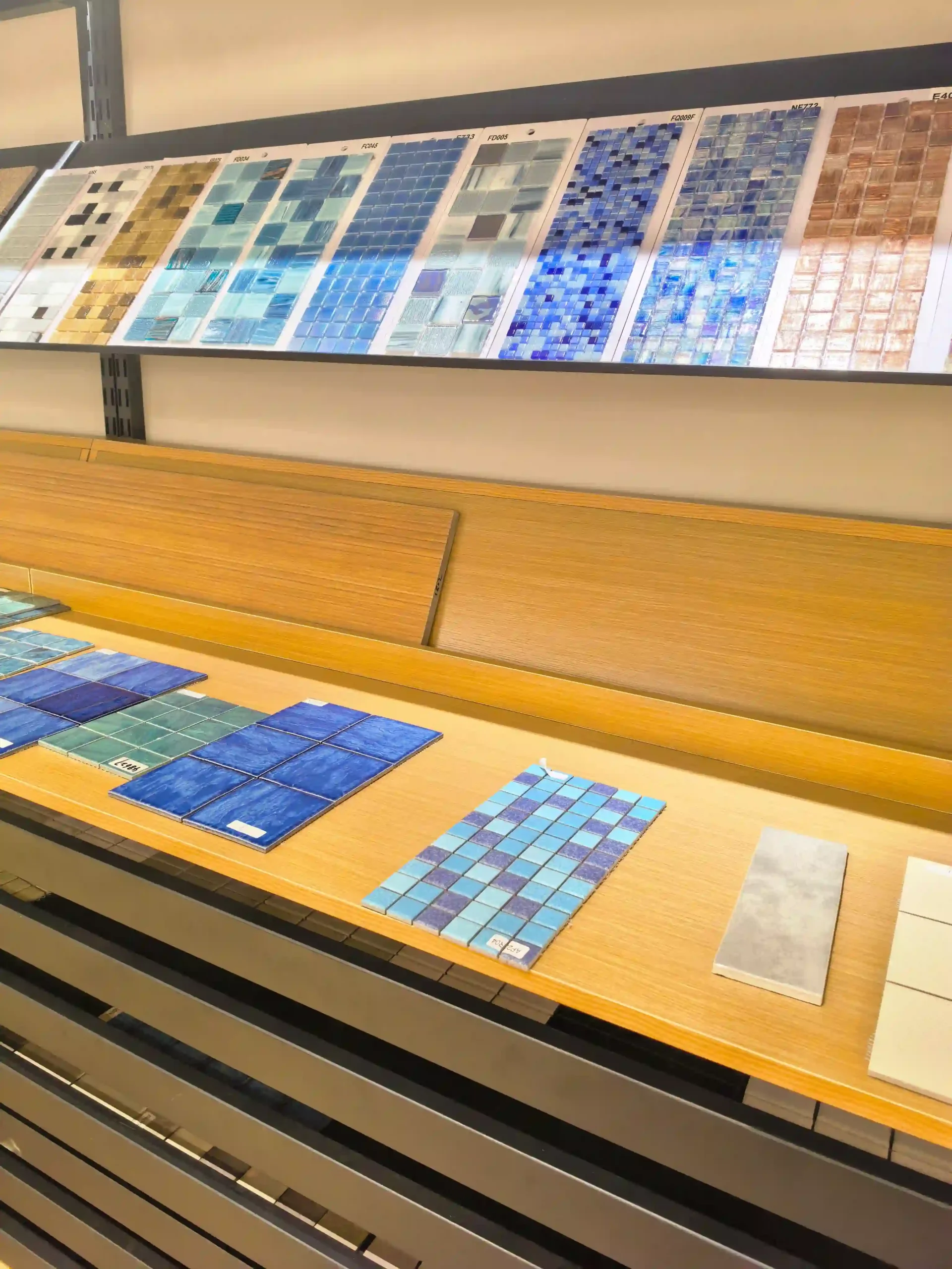 Blue, white and decorative mosaic tile samples displayed in a tile showroom