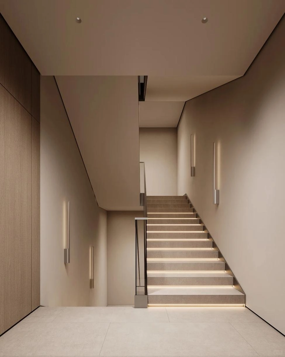 Modern indoor staircase finished with light-colored stair tiles and integrated lighting
